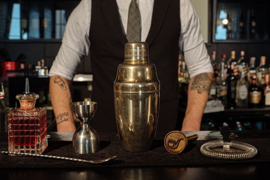 A bartender's setup with a cocktail shaker and bar tools