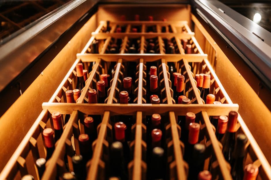 Wine bottles stored on their sides in a wooden rack