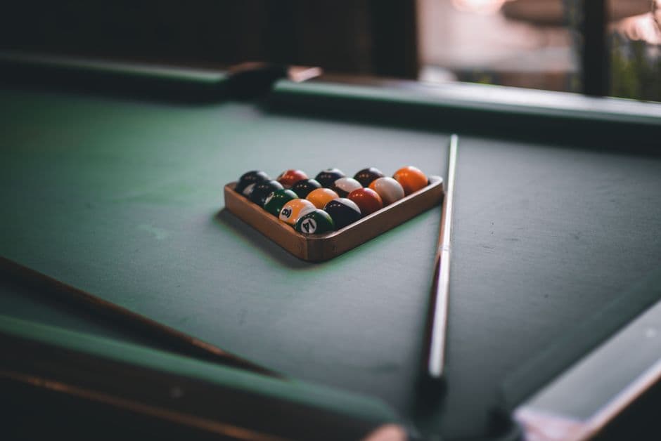 A billiard table with racked balls in a home game room