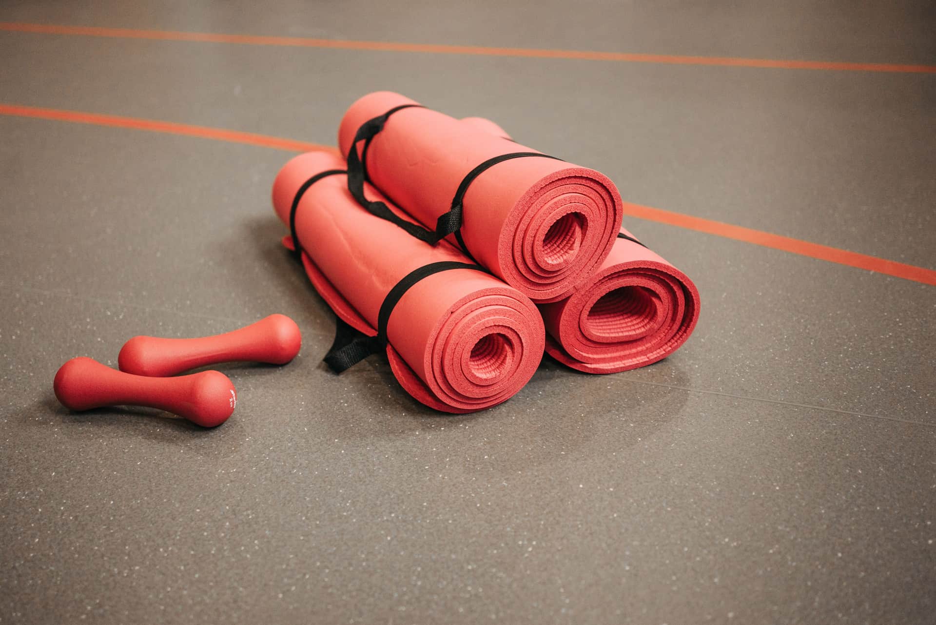 Rubber gym flooring, a mirror and resistance bands in a home gym